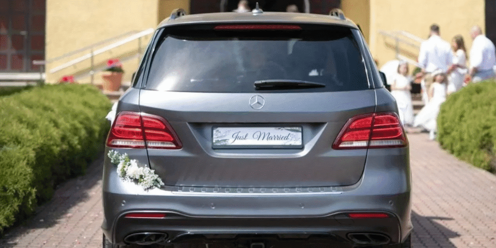 Samochód marki Mercedes, model GLE. Jest to zdjęcie przedstawiające tylną zewnętrzną część samochodu, jest on koloru czarnego i ma przystrojenie z lewej strony nad zderzakiem.